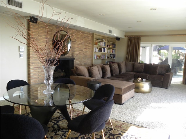 living room featuring carpet and a brick fireplace