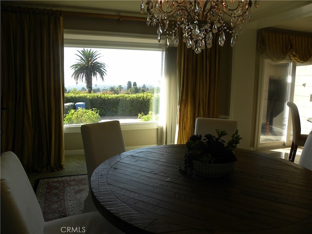 dining space with an inviting chandelier and carpet floors