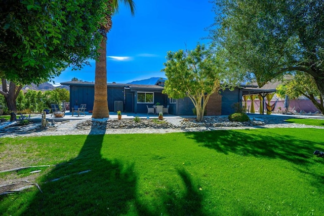 rear view of property with a yard and a patio