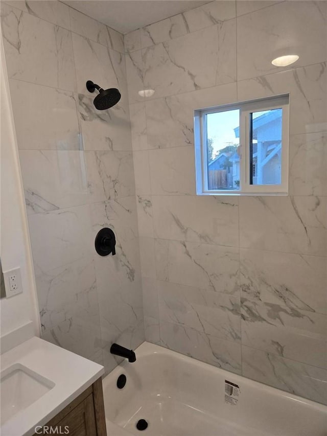 bathroom featuring vanity and tiled shower / bath