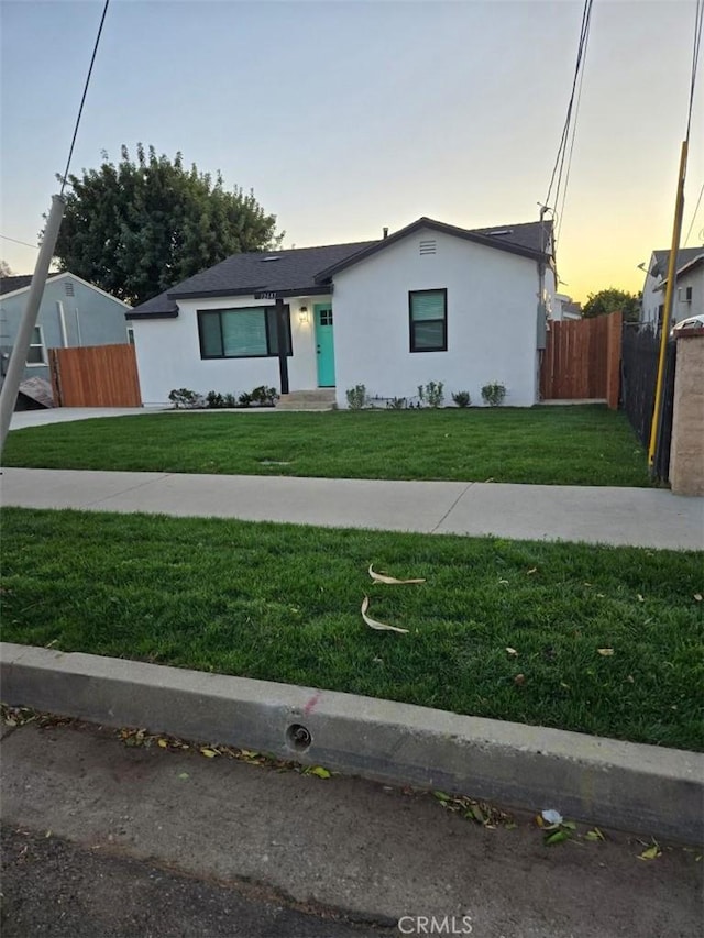 single story home featuring a lawn