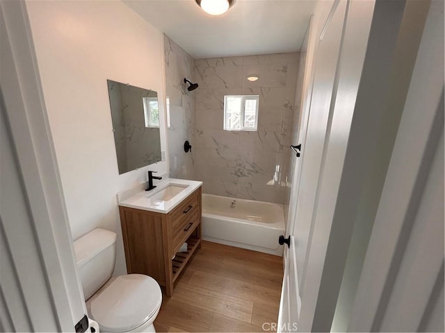 full bathroom featuring vanity, hardwood / wood-style flooring, toilet, and tiled shower / bath