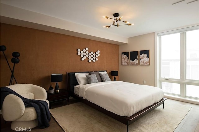 bedroom featuring wood-type flooring and an inviting chandelier