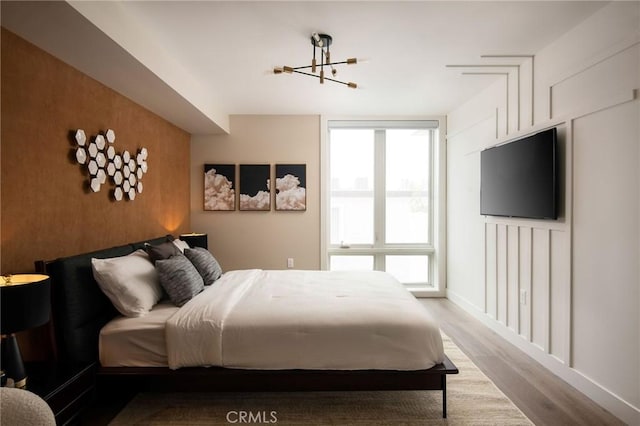 bedroom with an inviting chandelier and hardwood / wood-style flooring