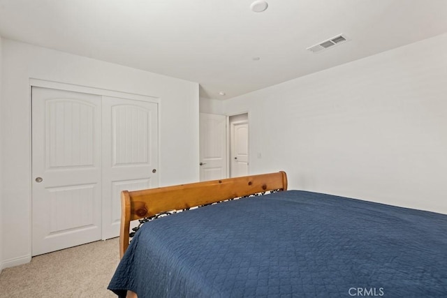 bedroom featuring light colored carpet and a closet