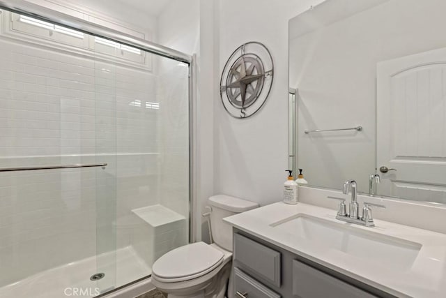 bathroom with vanity, a shower with shower door, and toilet