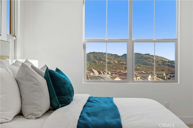 bedroom with a mountain view and multiple windows