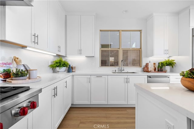 kitchen featuring white cabinetry, sink, appliances with stainless steel finishes, and light wood-type flooring