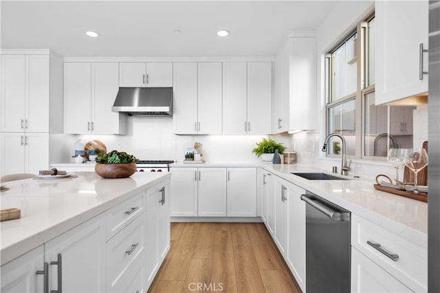 kitchen with sink, stainless steel dishwasher, extractor fan, white cabinets, and light wood-type flooring