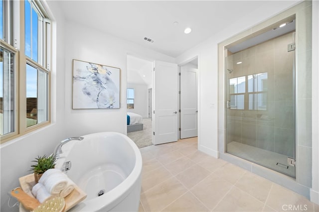 bathroom with tile patterned flooring, separate shower and tub, and a wealth of natural light