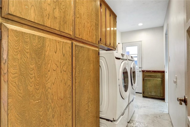 washroom with cabinets and washing machine and dryer