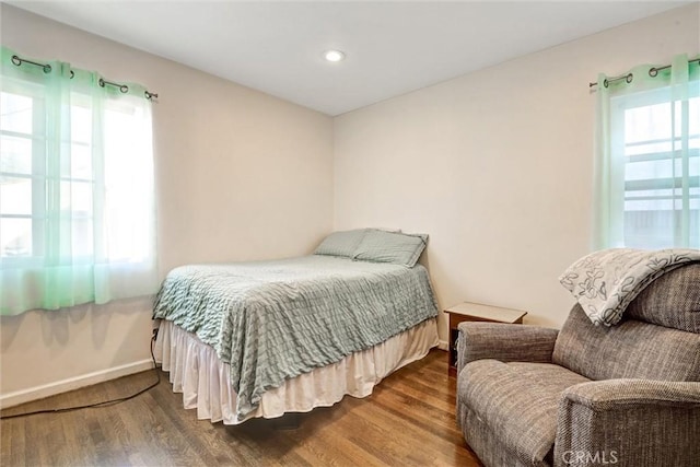 bedroom with wood-type flooring and multiple windows