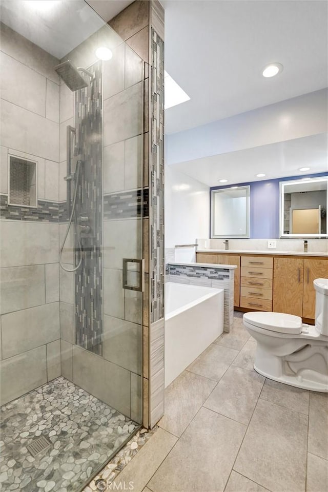 full bathroom with toilet, tile patterned floors, vanity, and separate shower and tub