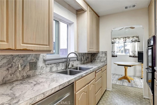 kitchen with light brown cabinets, double oven, ceiling fan, and sink