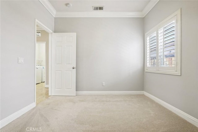 carpeted empty room with washer / clothes dryer and crown molding