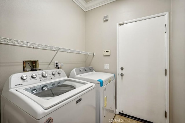 washroom featuring light tile patterned floors, washing machine and dryer, and ornamental molding