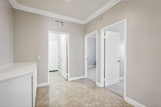 hallway featuring light tile patterned flooring and ornamental molding