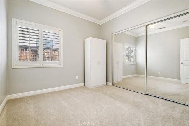 unfurnished bedroom with ornamental molding, multiple windows, light carpet, and a closet