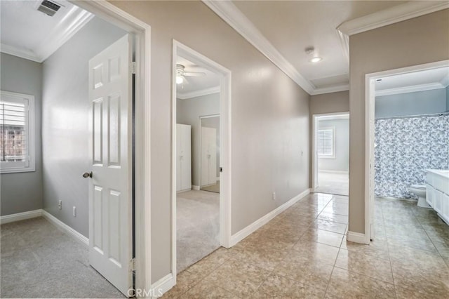 corridor featuring crown molding and light colored carpet