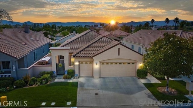 view of front of house featuring a mountain view, a yard, and a garage