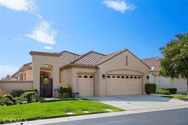 mediterranean / spanish home with a front lawn and a garage