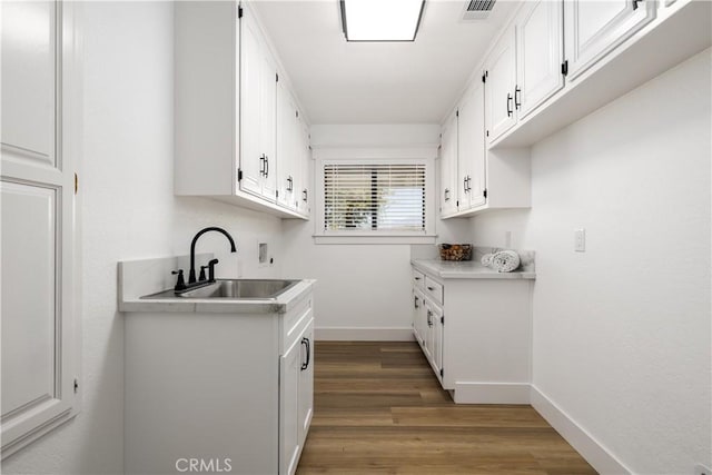 kitchen featuring dark hardwood / wood-style floors, white cabinetry, and sink