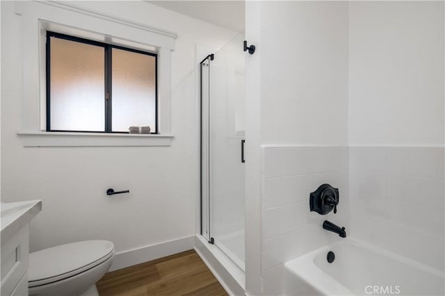 bathroom with hardwood / wood-style floors, toilet, and bath / shower combo with glass door