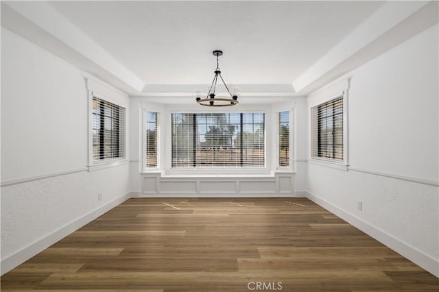 unfurnished sunroom with a tray ceiling and an inviting chandelier