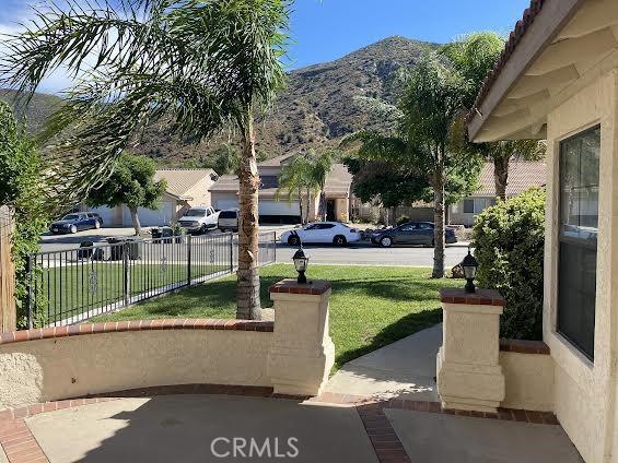 surrounding community with a mountain view and a yard