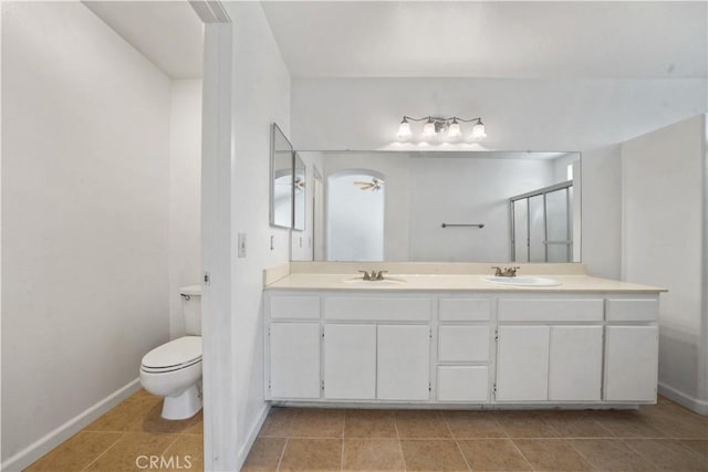 bathroom with tile patterned floors, vanity, toilet, and an enclosed shower