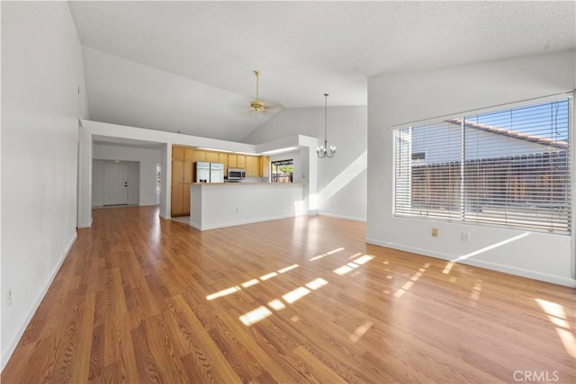 unfurnished living room featuring a textured ceiling, light hardwood / wood-style floors, an inviting chandelier, and high vaulted ceiling