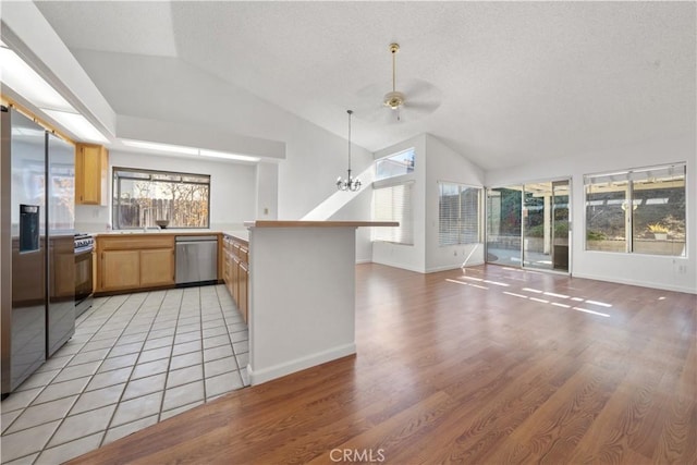 kitchen with kitchen peninsula, appliances with stainless steel finishes, light wood-type flooring, and plenty of natural light