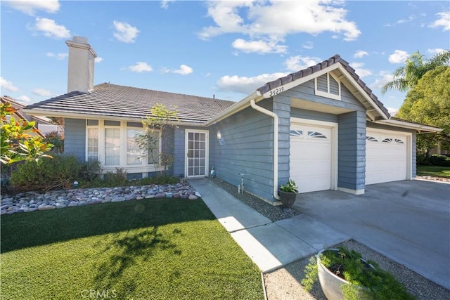 ranch-style house featuring a front lawn and a garage