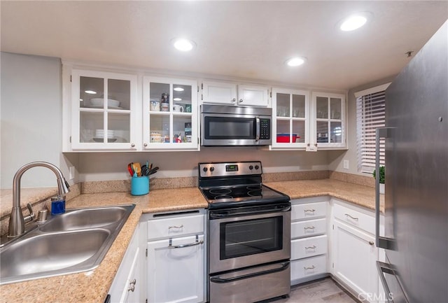 kitchen with sink, white cabinets, and appliances with stainless steel finishes