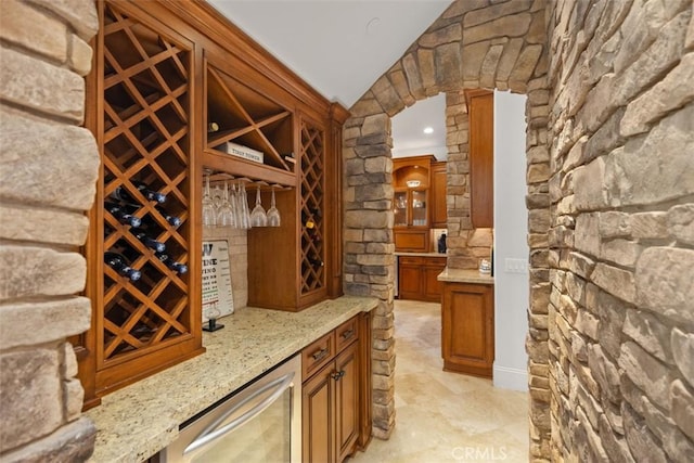 wine cellar with bar, beverage cooler, and lofted ceiling