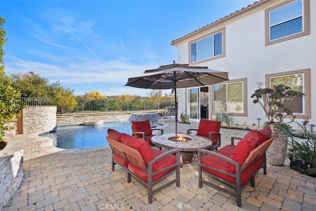 view of patio with pool water feature, a fenced in pool, and an outdoor living space with a fire pit