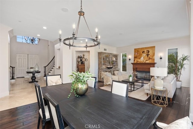 dining area featuring crown molding, dark hardwood / wood-style flooring, and an inviting chandelier