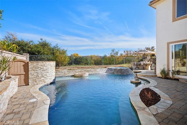 view of pool featuring an in ground hot tub, pool water feature, and a patio area