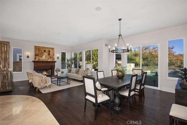 dining space featuring a healthy amount of sunlight, ornamental molding, and dark wood-type flooring