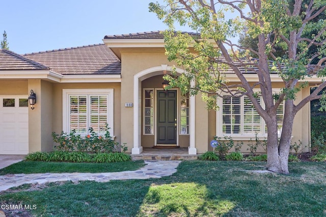 entrance to property with a yard and a garage