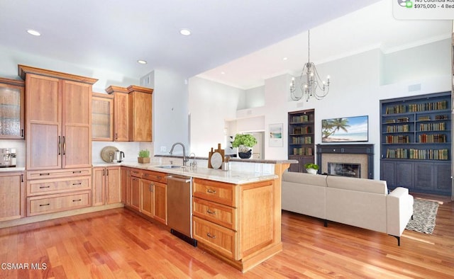 kitchen with dishwasher, light hardwood / wood-style floors, sink, and a chandelier