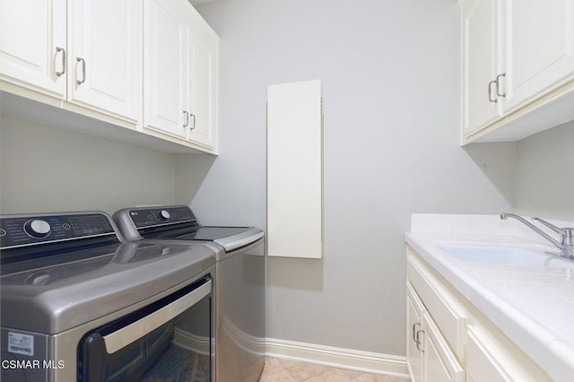 clothes washing area with washing machine and dryer and cabinets