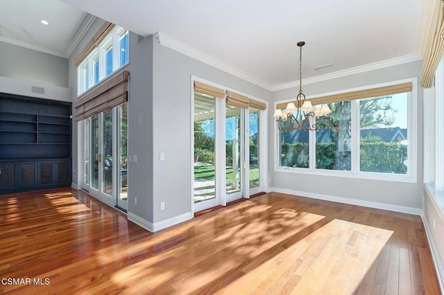 unfurnished dining area with plenty of natural light, ornamental molding, and hardwood / wood-style flooring