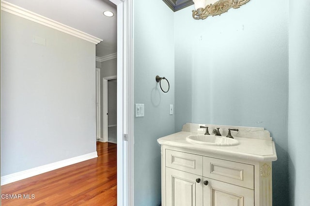 bathroom with crown molding, hardwood / wood-style floors, and vanity