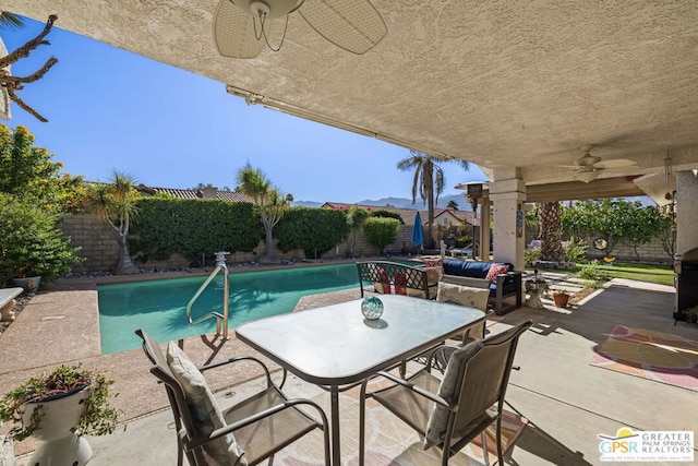 view of swimming pool with ceiling fan, a mountain view, and a patio