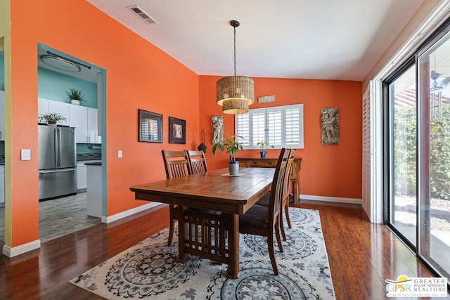 dining space featuring dark hardwood / wood-style floors, a wealth of natural light, and vaulted ceiling