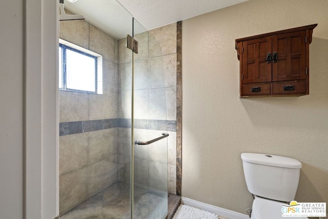 bathroom with a shower with shower door and toilet