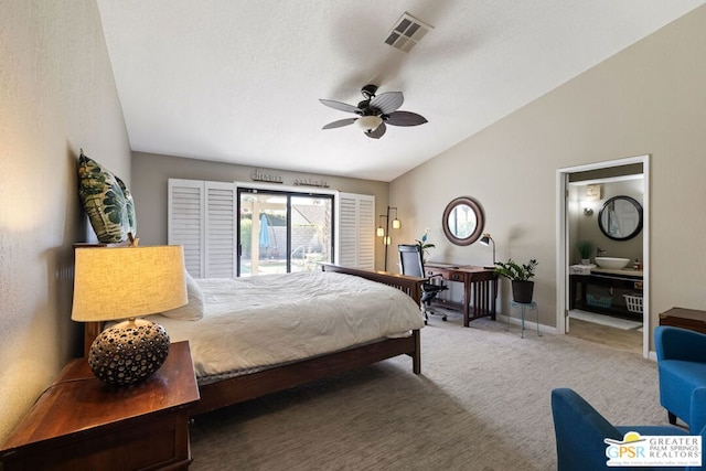 carpeted bedroom with ceiling fan, lofted ceiling, and connected bathroom