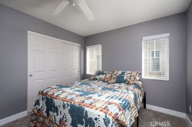 carpeted bedroom featuring ceiling fan, a closet, and multiple windows