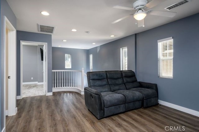 living room with ceiling fan and dark hardwood / wood-style flooring